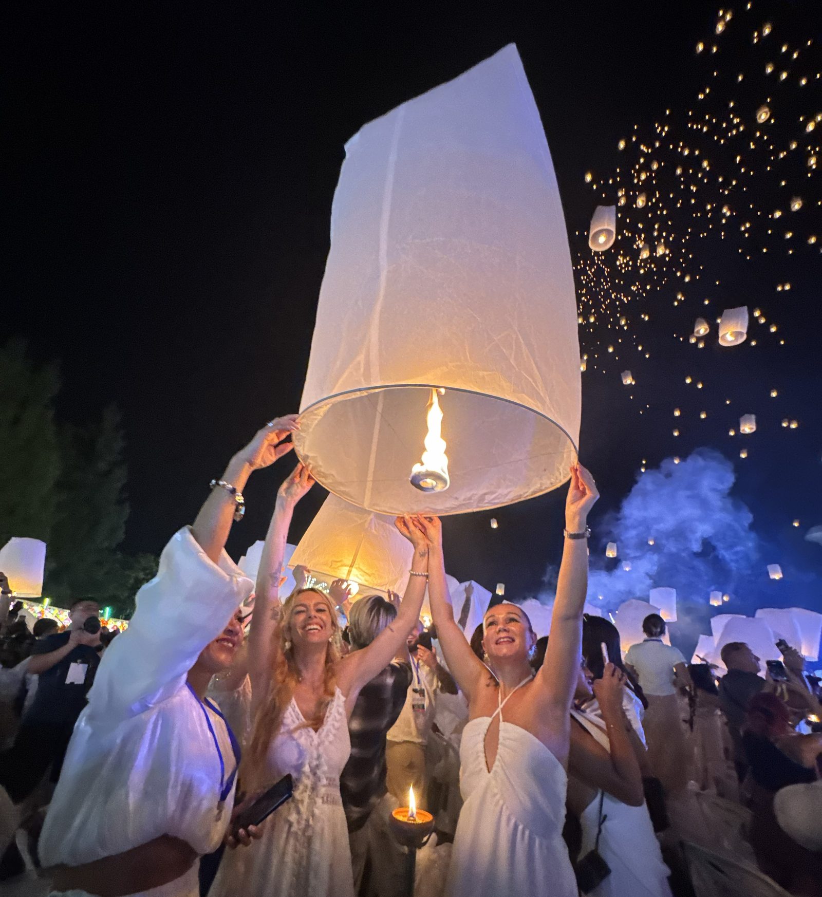 Mujeres elevando linternas de papel en el festival de Tailandia