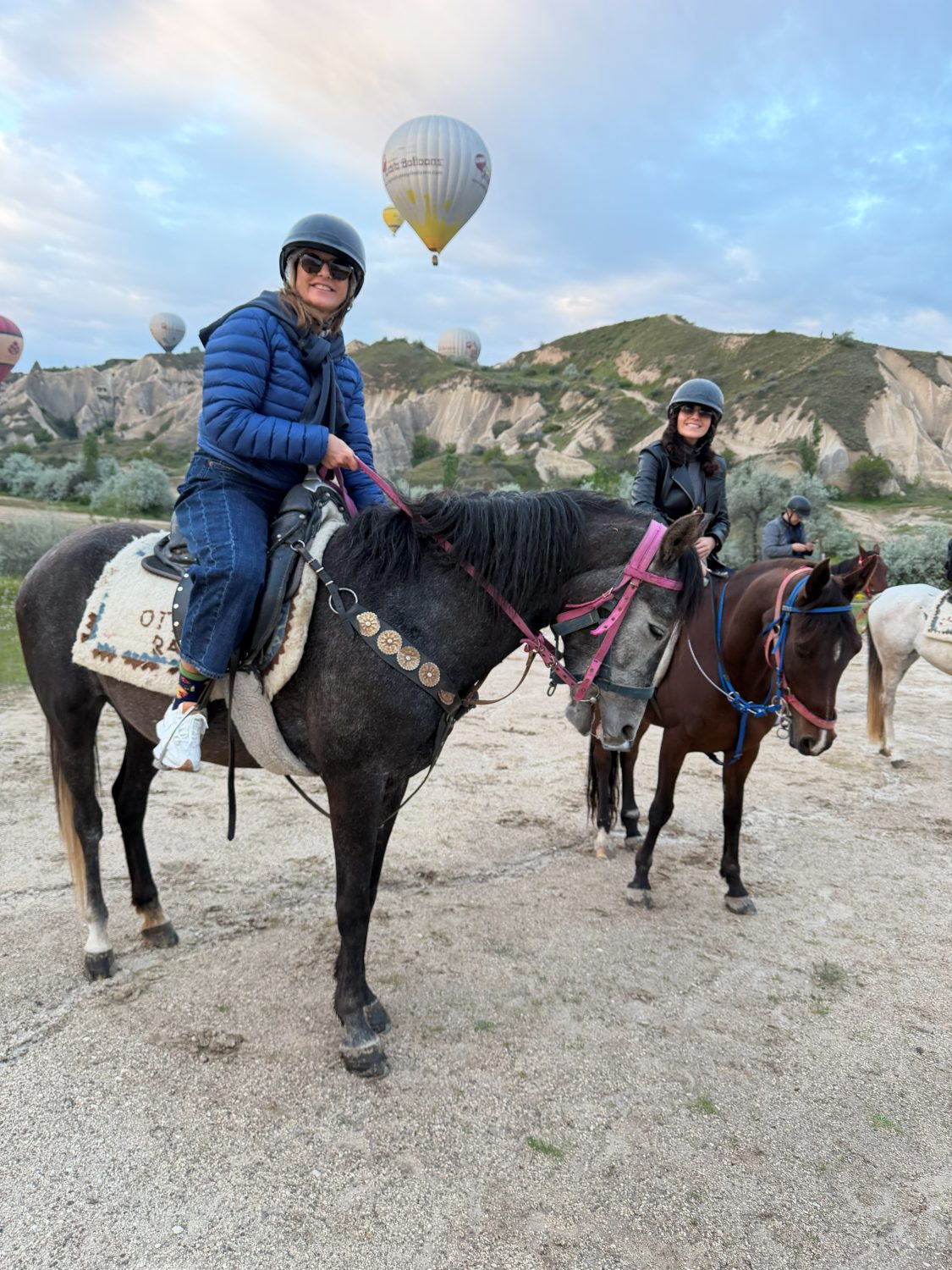 Viajera a caballo con los globos de Capadocia al amanecer