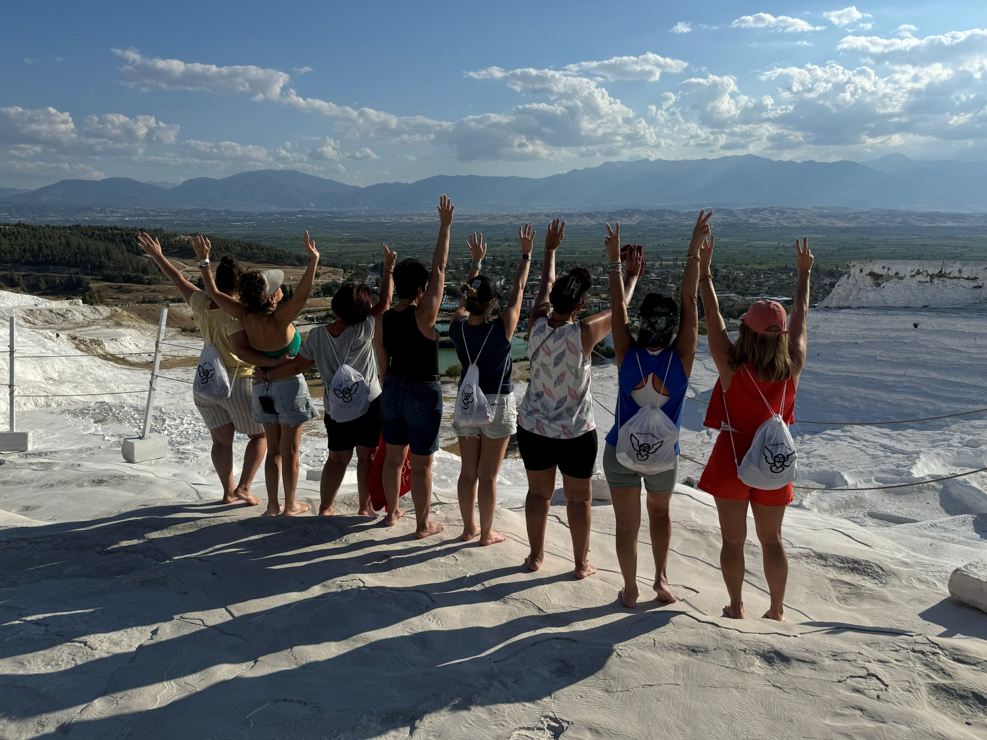 Viajeras con los brazos en alto en las terrazas blancas de Pamukkale