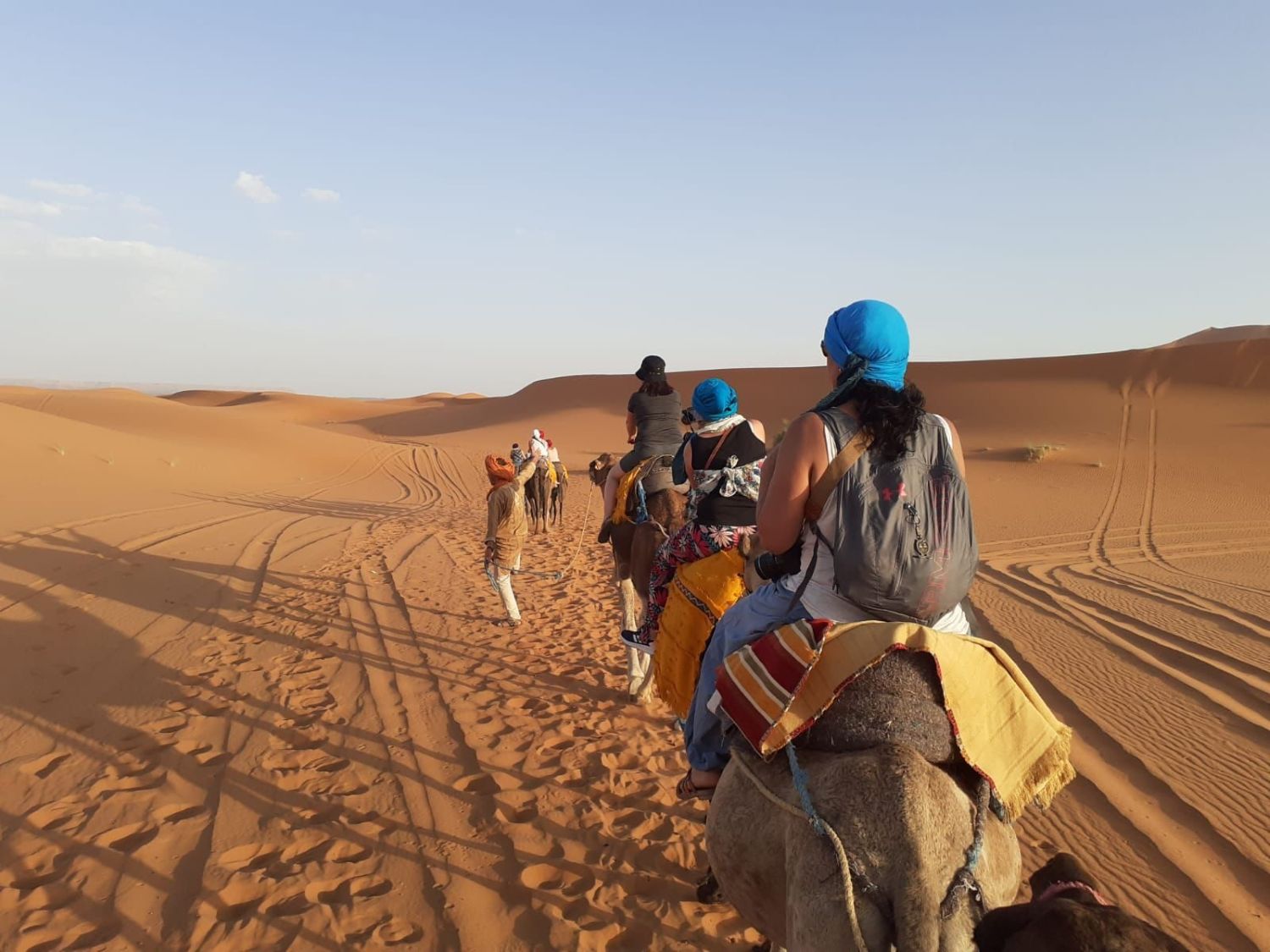 Caravana de viajeras en camello por las dunas